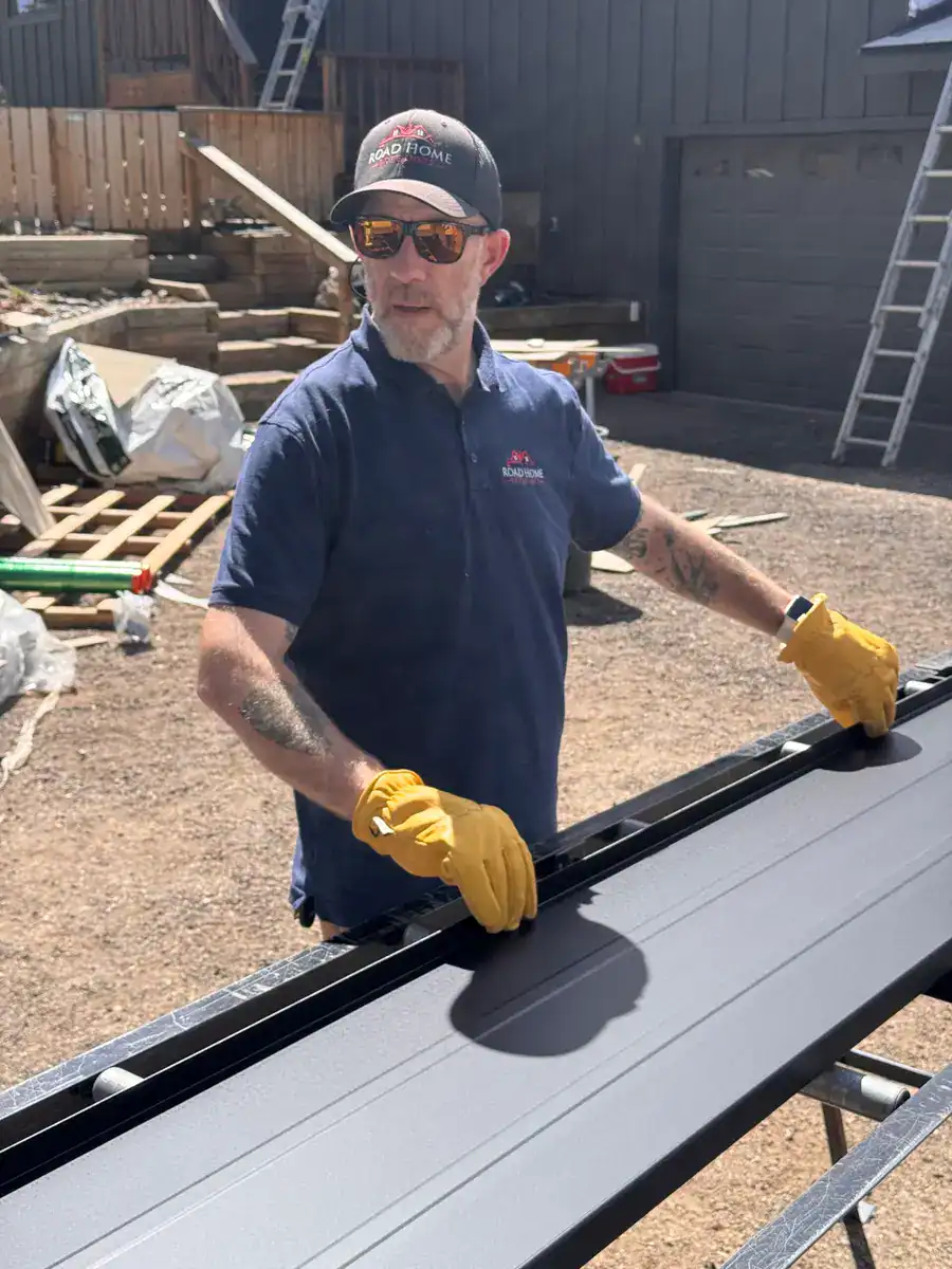 Road Home Exteriors team member preparing standing seam metal roofing panels during a residential metal roof installation in Colorado