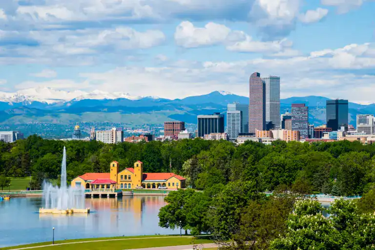 Denver skyline with City Park, Rocky Mountains, and surrounding neighborhoods representing roof replacement, siding replacement, and window replacement services in Denver, Colorado.