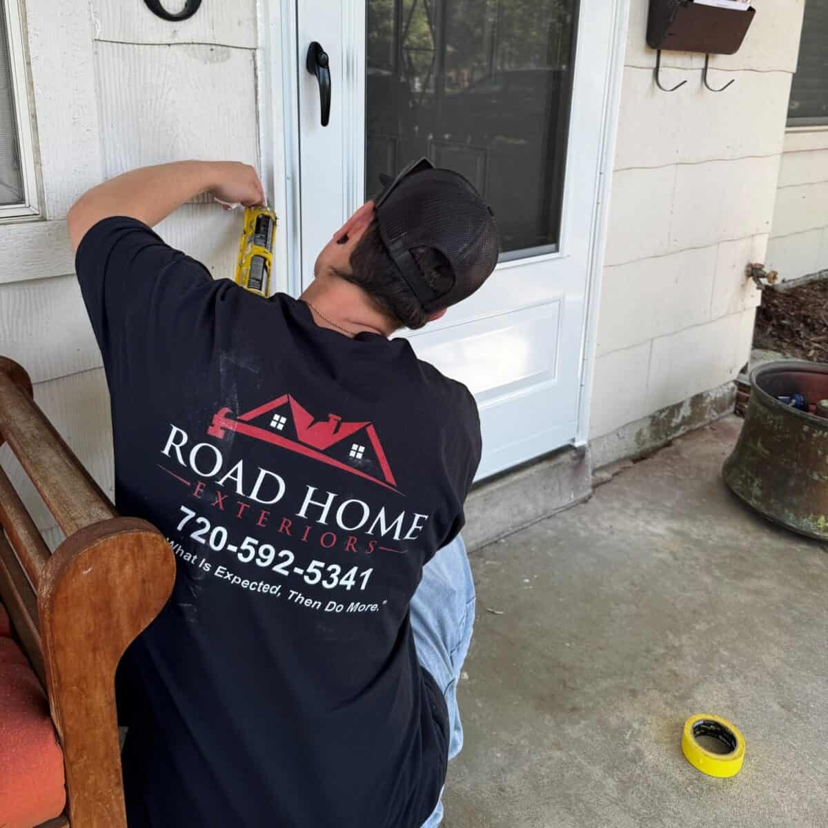 Road Home Exteriors installer sealing a new Pella entry door during a professional door installation in Aurora, Colorado.