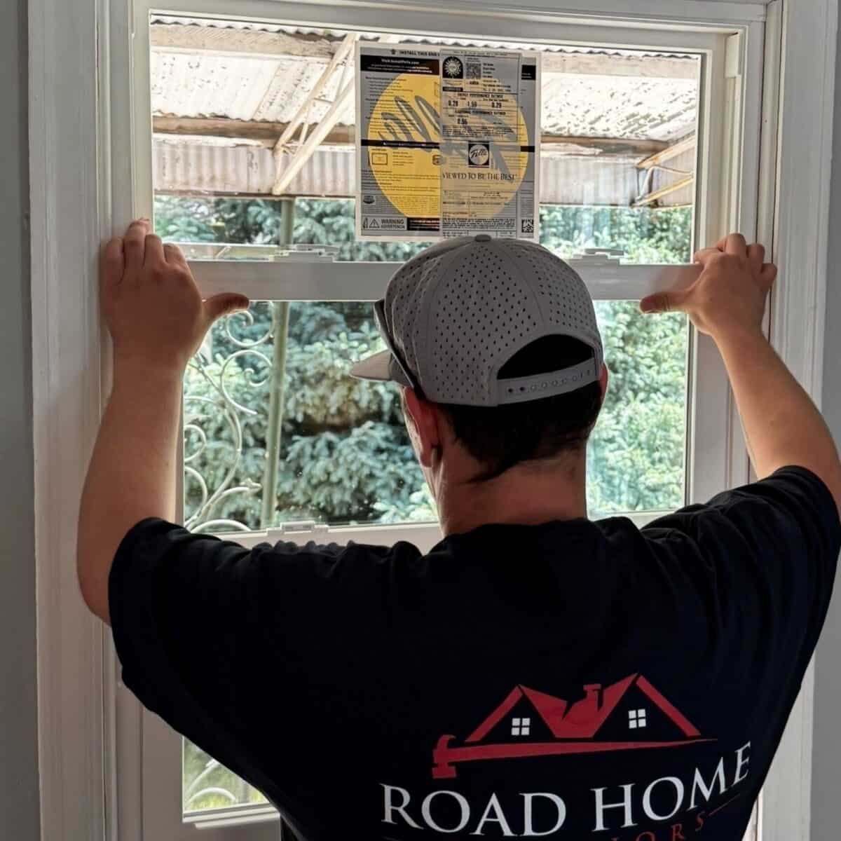 Road Home Exteriors installer positioning a new Pella replacement window during a professional window installation in Arvada, Colorado.