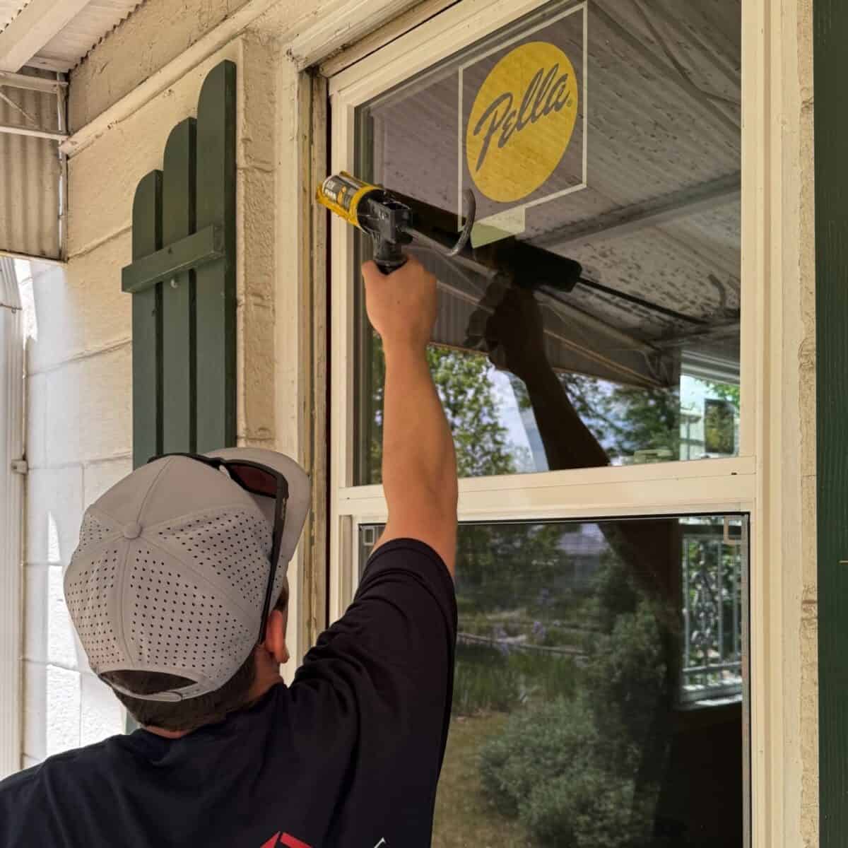 Road Home Exteriors installer sealing a new Pella replacement window during a professional window installation in Littleton, Colorado.