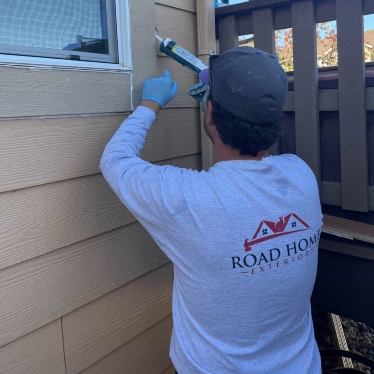 Road Home Exteriors installer sealing a Simonton replacement window during a professional window installation in Highlands Ranch, Colorado.