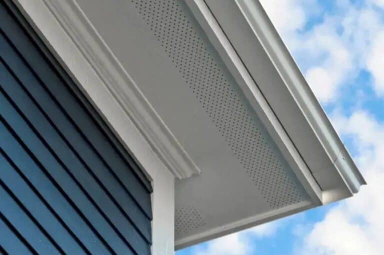 White soffit and fascia beneath the roof overhang of a blue-sided home