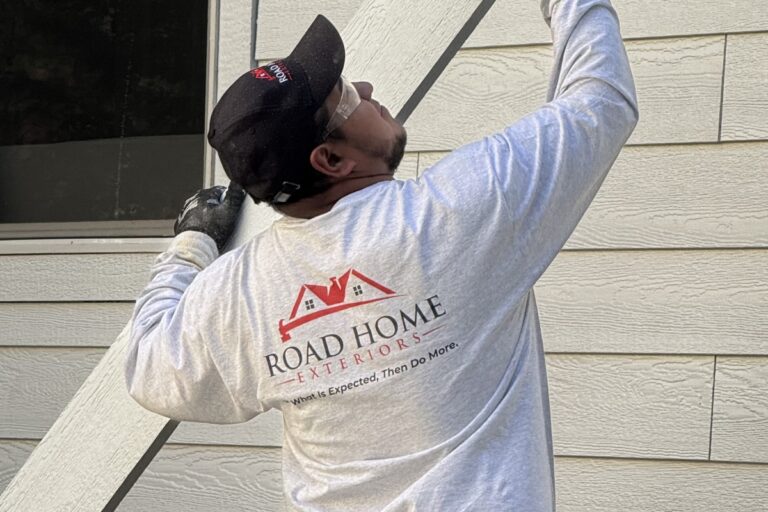 Road Home Exteriors installer working on residential siding