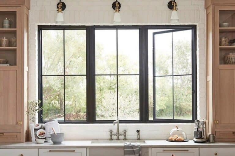 Row of black-framed windows overlooking trees outside a Colorado-style home