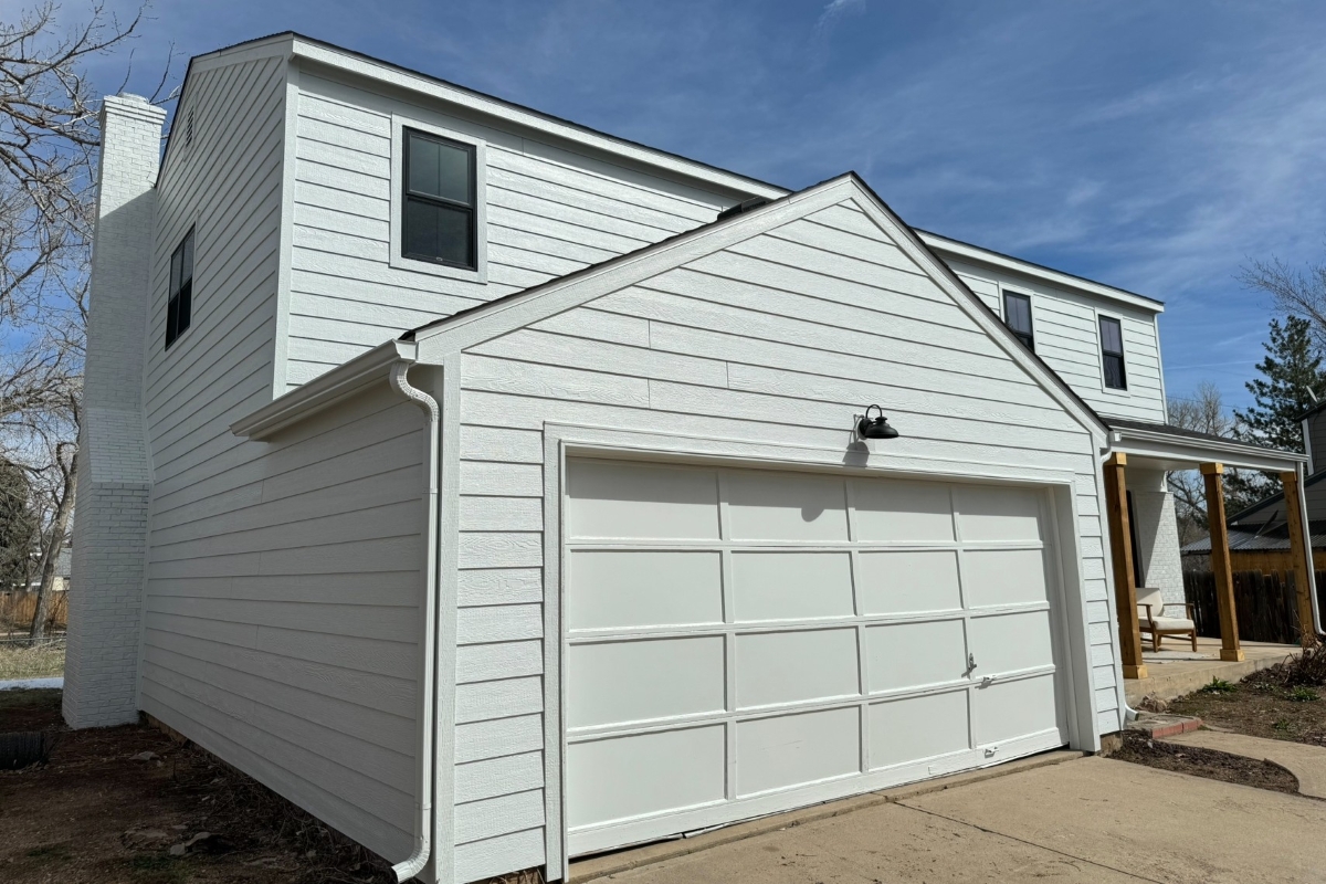 Friendly Hills home in Morrison after roofing, siding, and window updates, with white siding and dark window frames