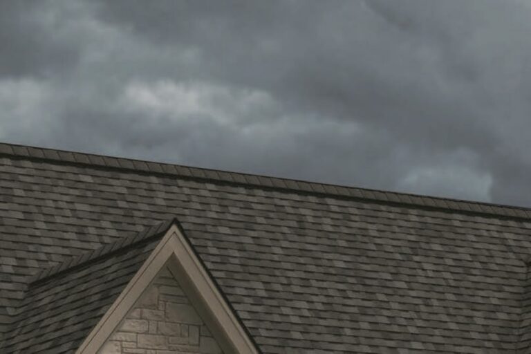 Owens Corning Duration STORM shingles on a roof above a stone gable beneath cloudy skies