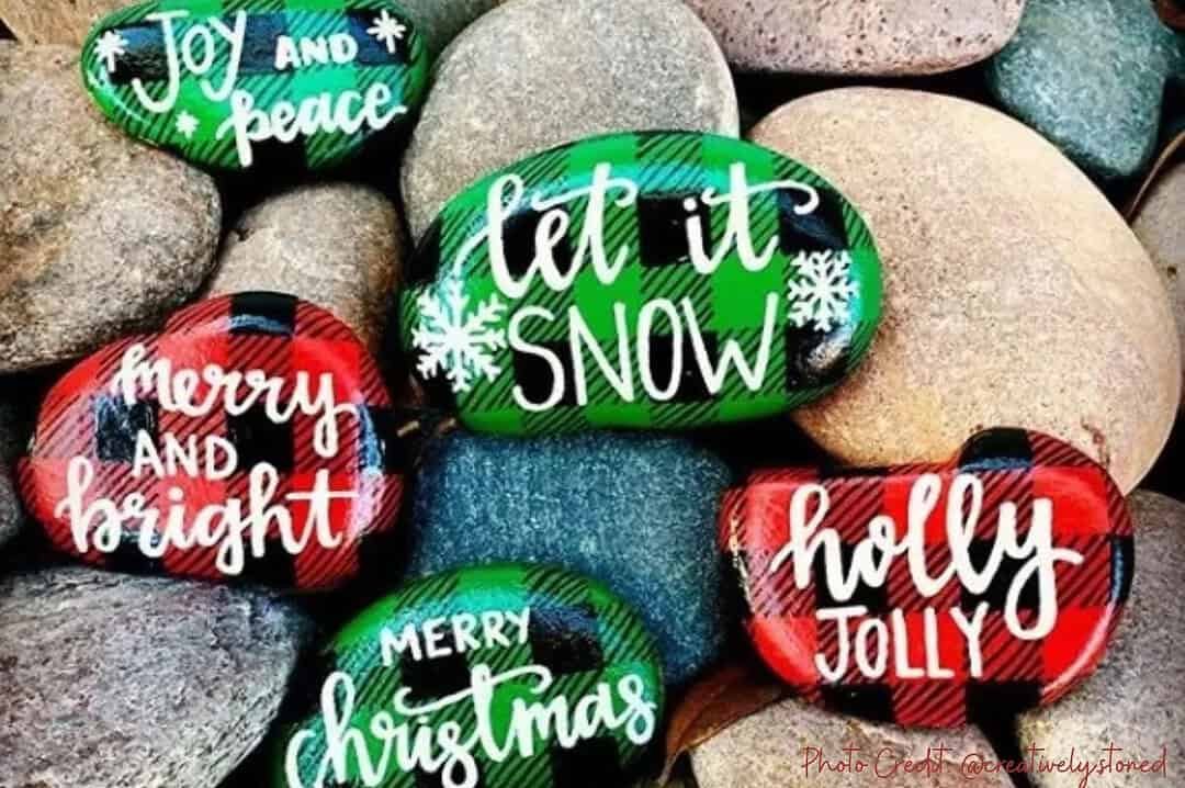 200+ Christmas Quotes and Sayings for Crafts (Free Printable) 4 Let it Snow rock painting with festive holiday messages on colorful pebbles.