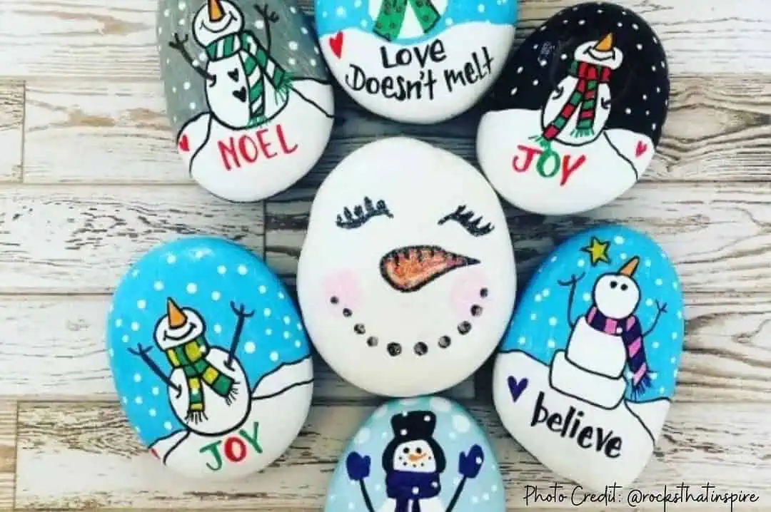 200+ Christmas Quotes and Sayings for Crafts (Free Printable) 3 Snowman painted rock with cheerful designs and holiday messages.