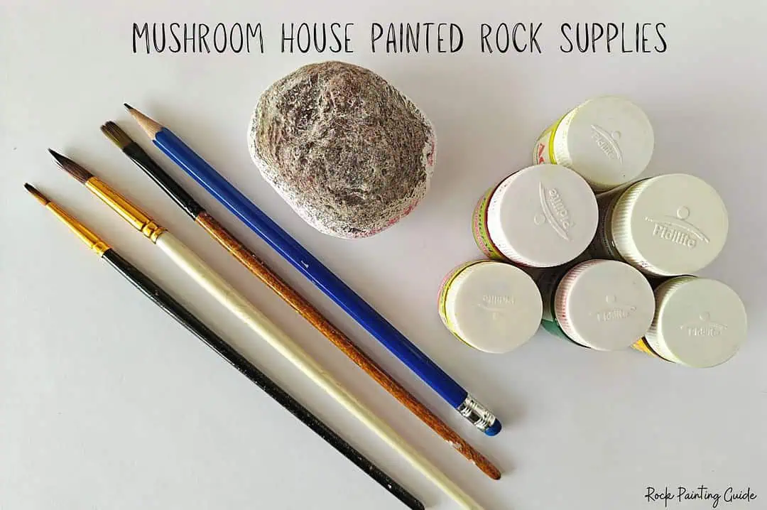 Cute Mushroom House Painted Rocks: Easy Fairy Garden DIY 4 rock painting supplies of a rock, paint brushes, and craft paint for the mushroom house painted rocks craft