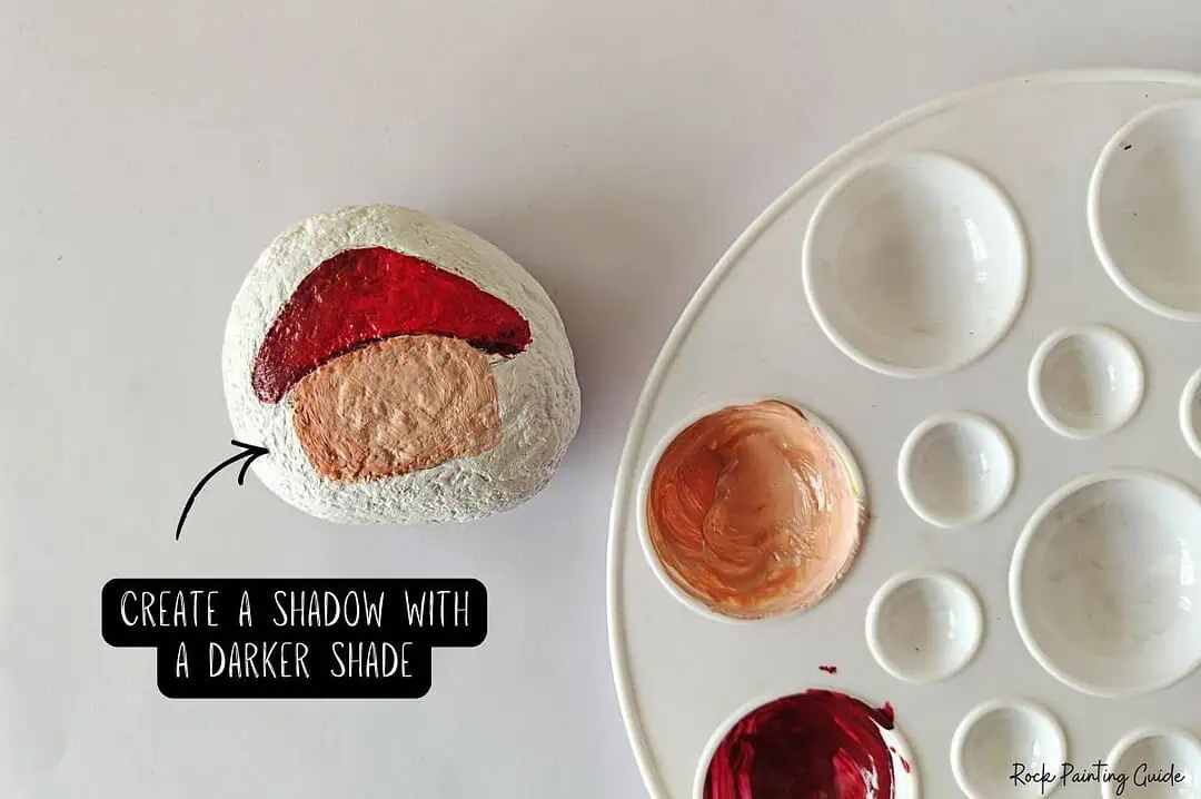 Cute Mushroom House Painted Rocks: Easy Fairy Garden DIY 10 Hand-painted mushroom house painted rock with red, beige, and white colors for rock art projects.