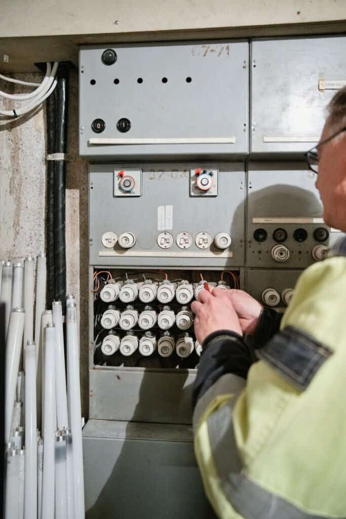 Sähköasentaja työskentelee sähkökaapin parissa.