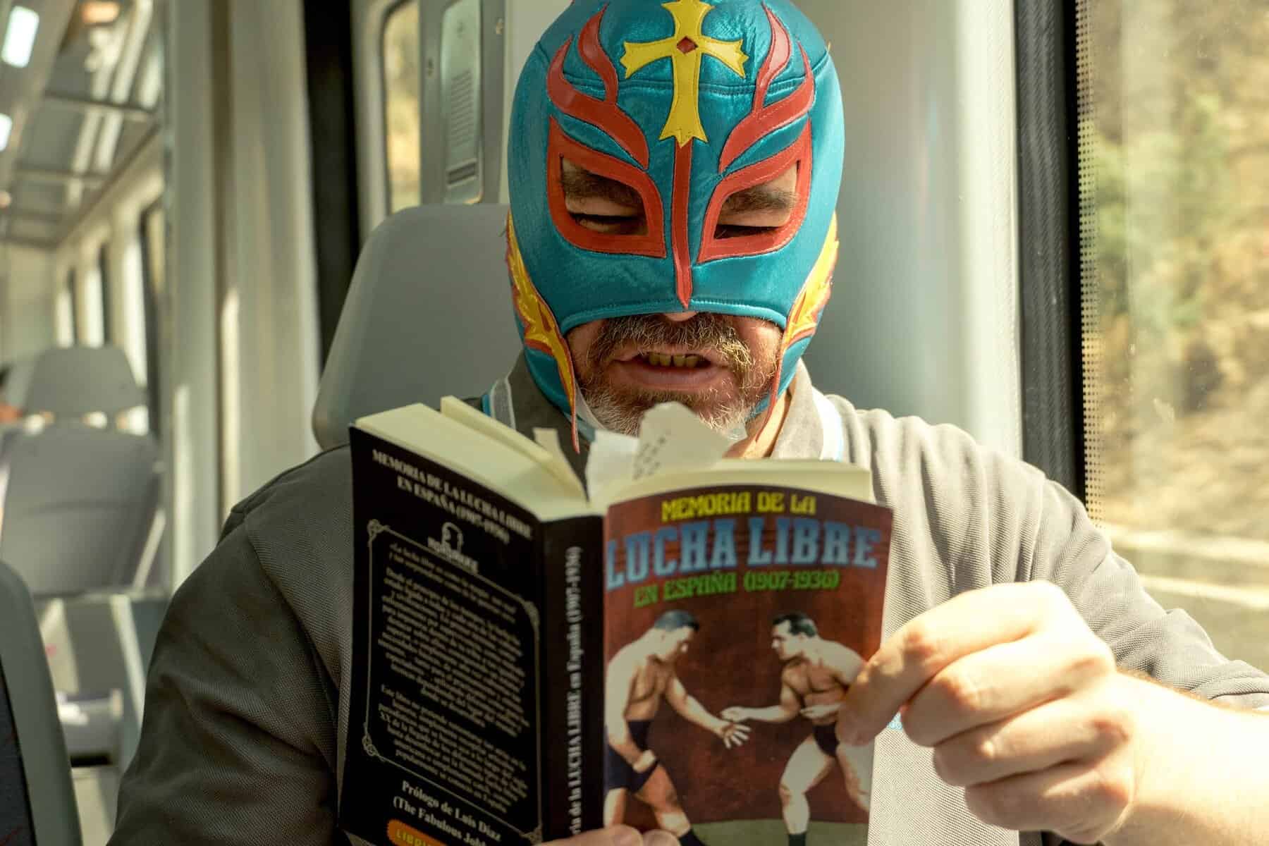 a man wearing blue and red mask reading book