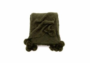 Mörkgrön stickad filt med pompomkant för mysiga sovstunder.