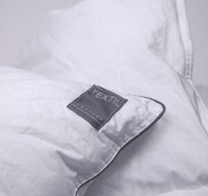 Lakan med textiltäcke och kvalitetsmärkning för sängkomfort.