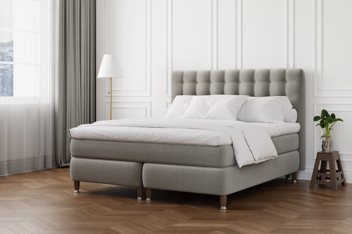 New ORGANIC KONTINENTAL SANGFABRIKEN interior Tiffany Grey copy Heltäckande säng med stubbad huvudgavel och vita sängkläder i ett modernt sovrum.