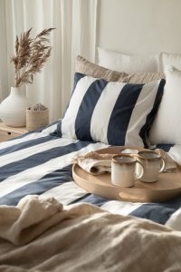 1. Sängtäcke i marinblå och vit rand design för elegant sovrumsstil.
