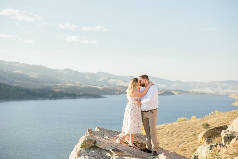 Couple sharing a kiss with beautiful scenic backdrop at Horsetooth in Fort Collins