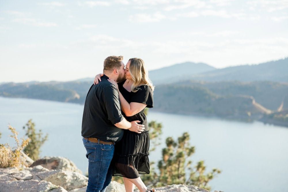 Couple sharing a kiss with beautiful scenic backdrop at Horsetooth in Fort Collins