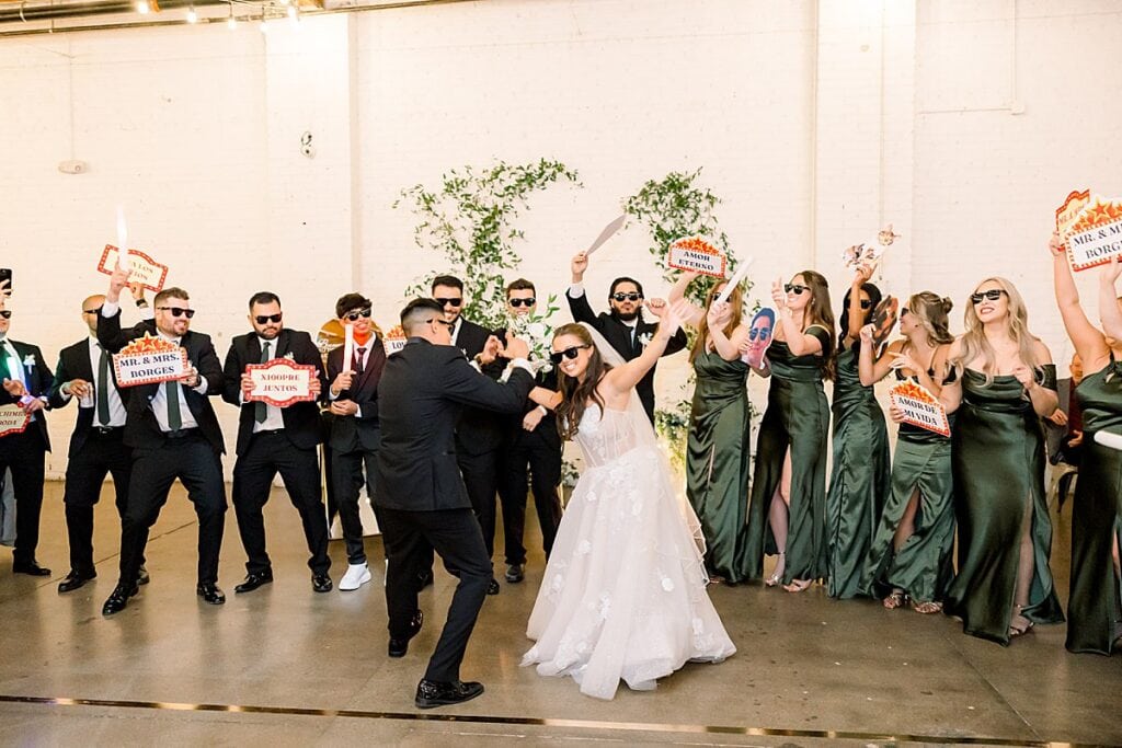 Bride and groom dancing with bridal party at reception