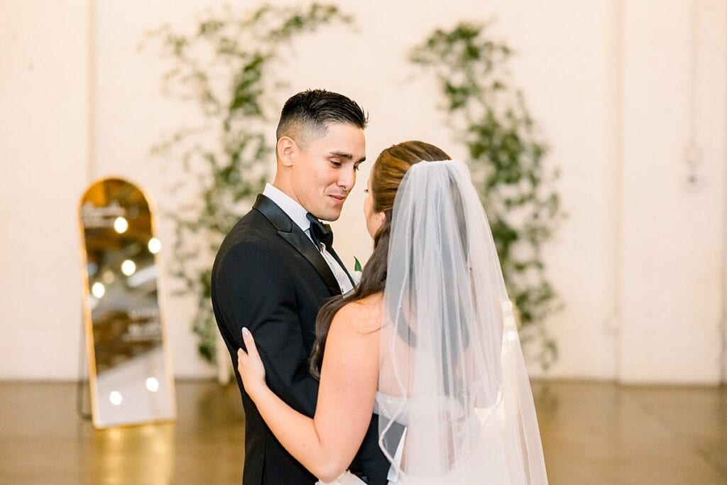 Groom gazing lovingly at bride during first dance
