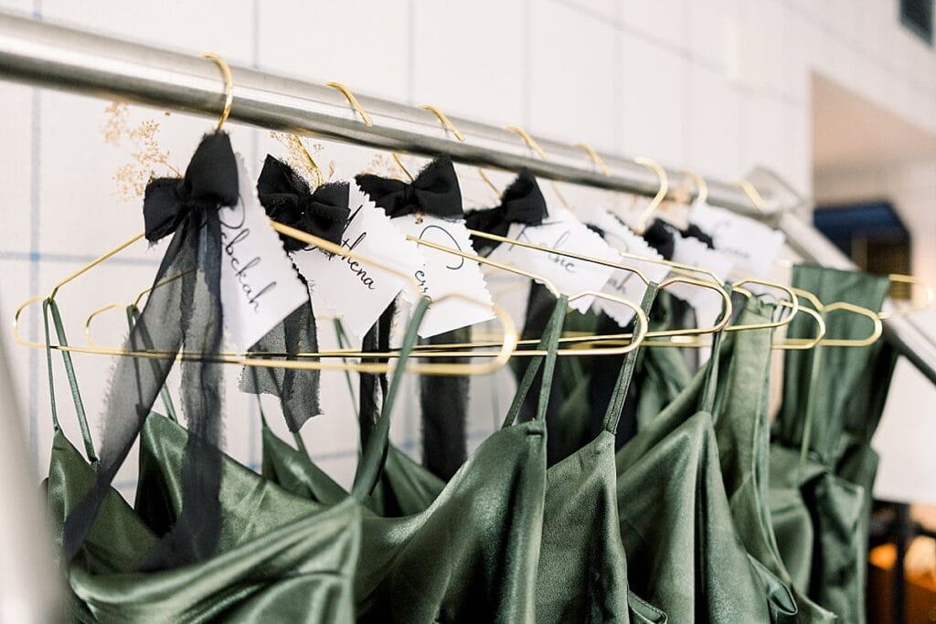 Bridesmaid details of dresses on their hangers with name beautiful tags