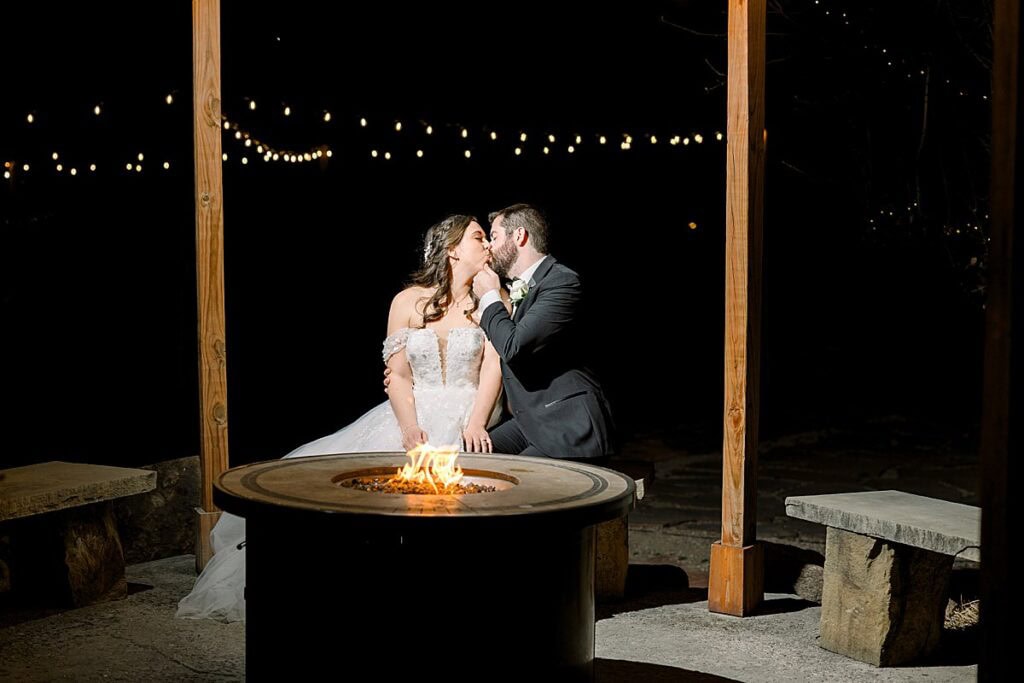 Bride and Groom sharing kiss in front of fireplace