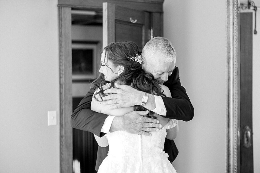 Bride hugging father after he sees her for the first time in her wedding dress
