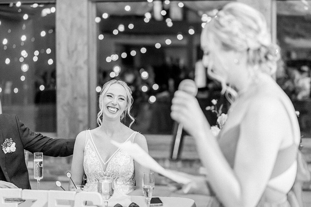 Bride smiling at her sister during toast