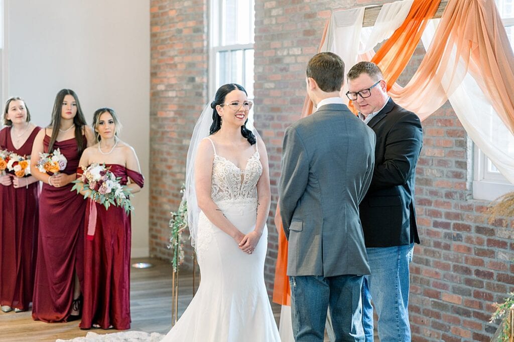Bride smiling at groom during ceremony