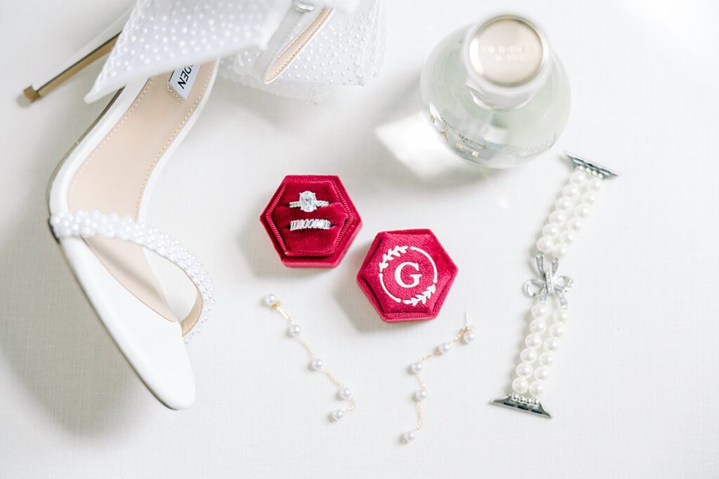 wedding details including brides shoes, rings, perfume, earrings, and bracelet