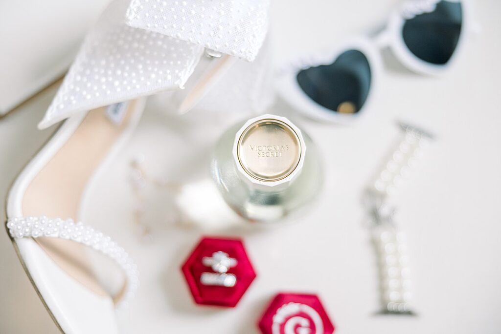 wedding details including brides shoes, rings, perfume, earrings, and bracelet