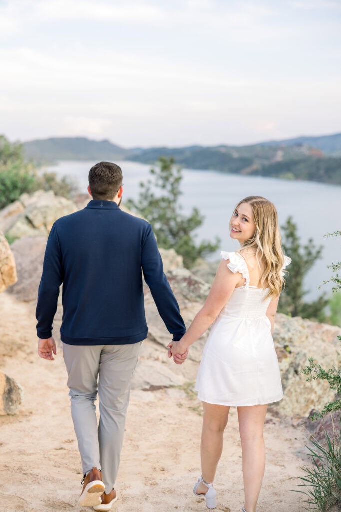 couple walking and girl is smiling at the camera over her shoulder