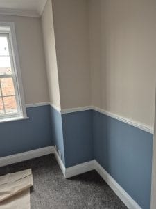 Freshly painted two-tone interior wall with elegant blue and white colour scheme | S Bond Decorating.
