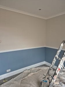 Bright interior wall painting with two-tone colour scheme, precise ceiling and skirting paintwork.
