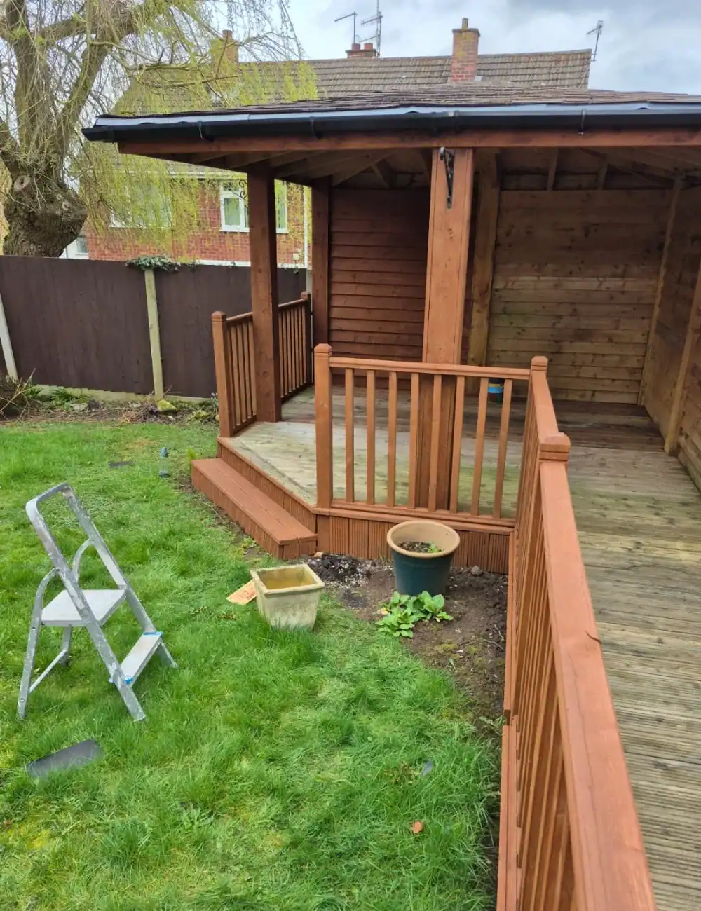 Decorative garden shed with wooden fencing by S Bond Decorating.