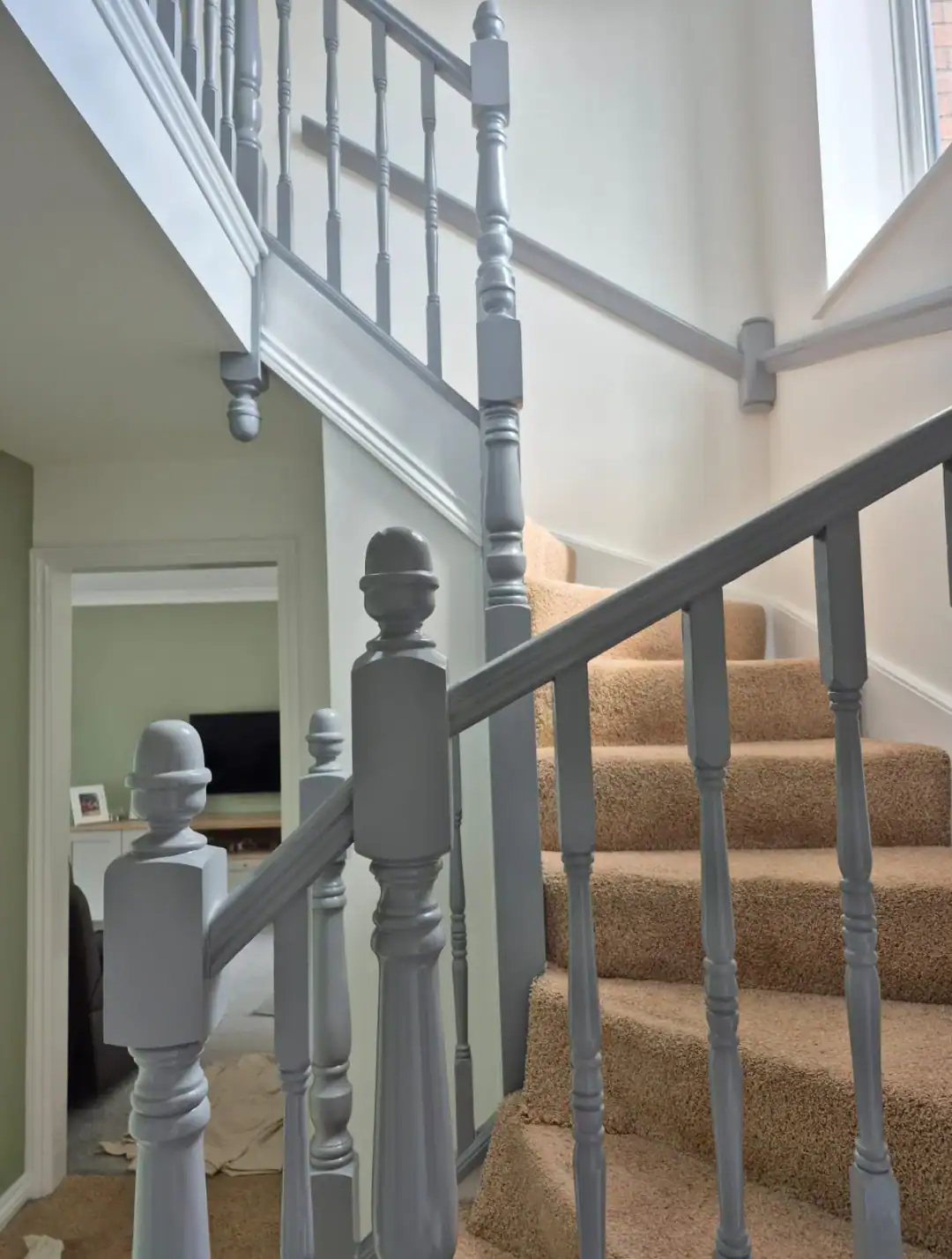 Bright painted staircase featuring satin grey banisters and new wall paint, showcasing professional decorating services.