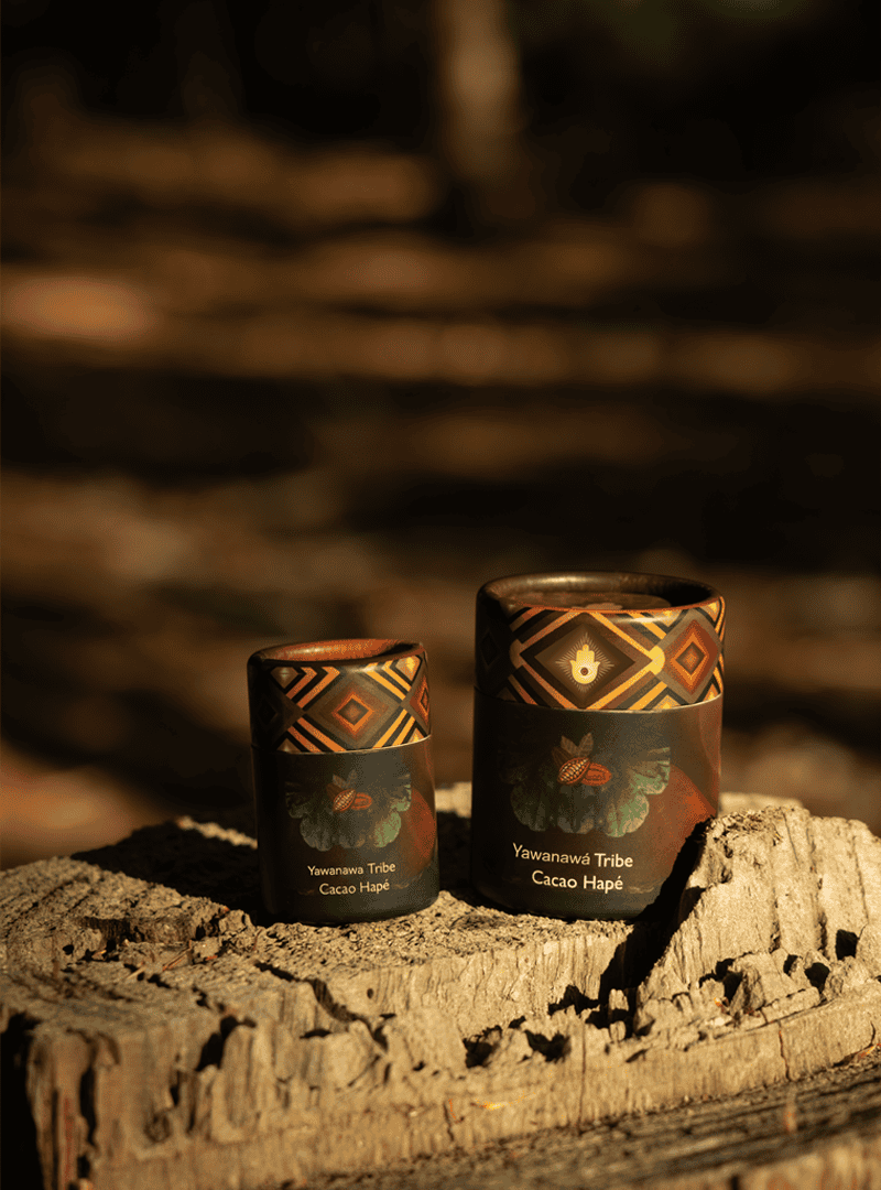 Handcrafted indigenous cacao containers with tribal designs, representing Yawanawa Tribe, in an outdoor natural setting for traditional healing and spiritual connection.