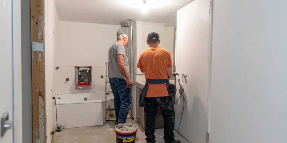 Two-Plumbers-Working-On-Bathroom-Plumbing-Renovation | Sheet Happens Plumbing & Drain