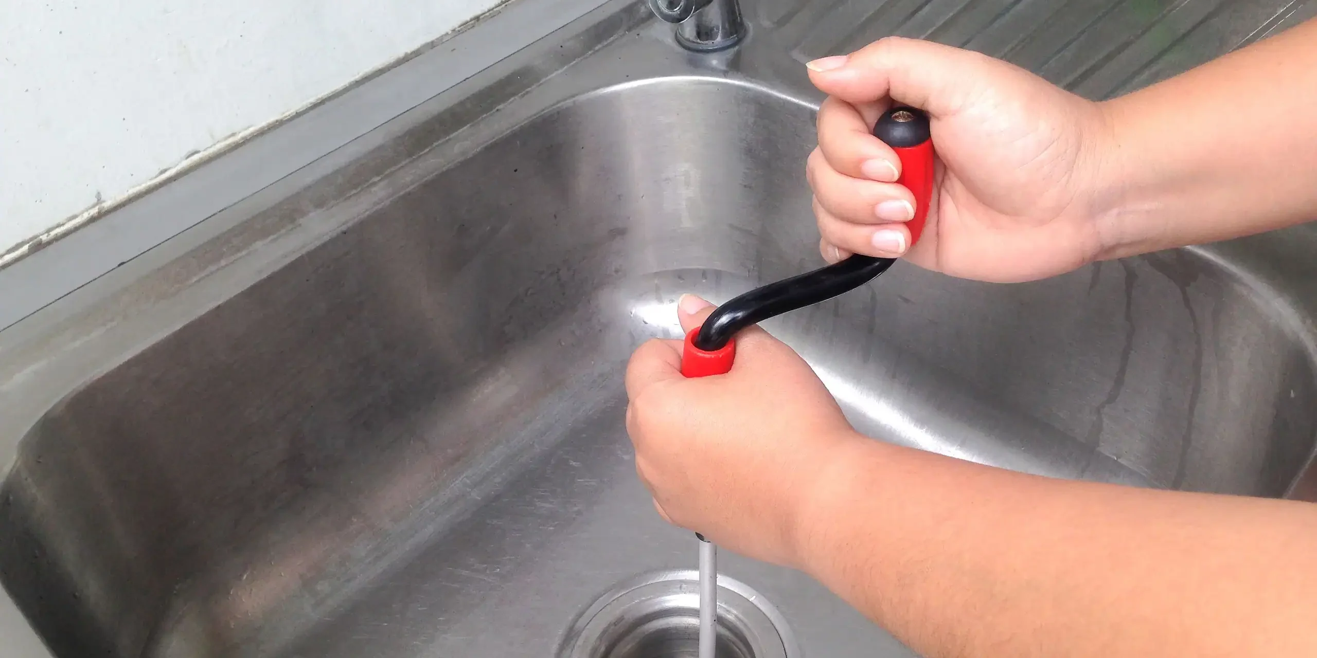 Drain-Snake-Clearing-Clogged-Kitchen-Sink-Drain Sheet Happens Plumbing & Drain