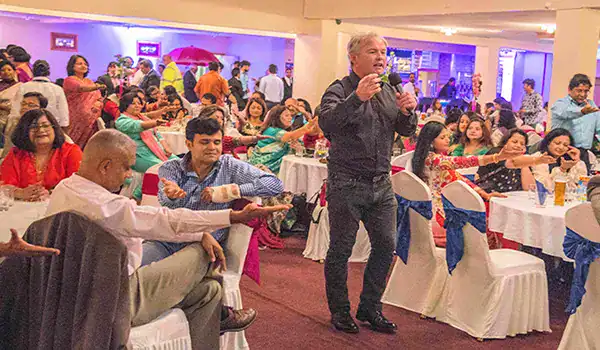 Man speaking at crowded indoor event