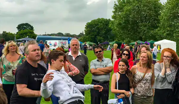 Crowd watches outdoor magic trick demonstration.