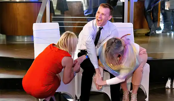 People laughing and playing game at a party.