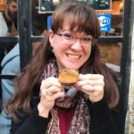 Delighted woman enjoying coffee at Singing Feather Ministries community event.