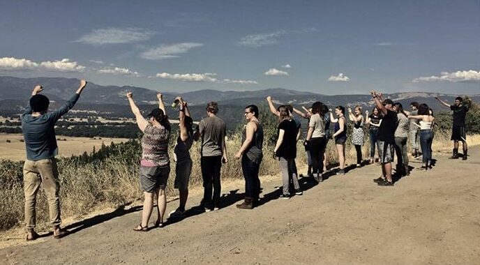Healing prayer group outdoor retreat in scenic landscape.