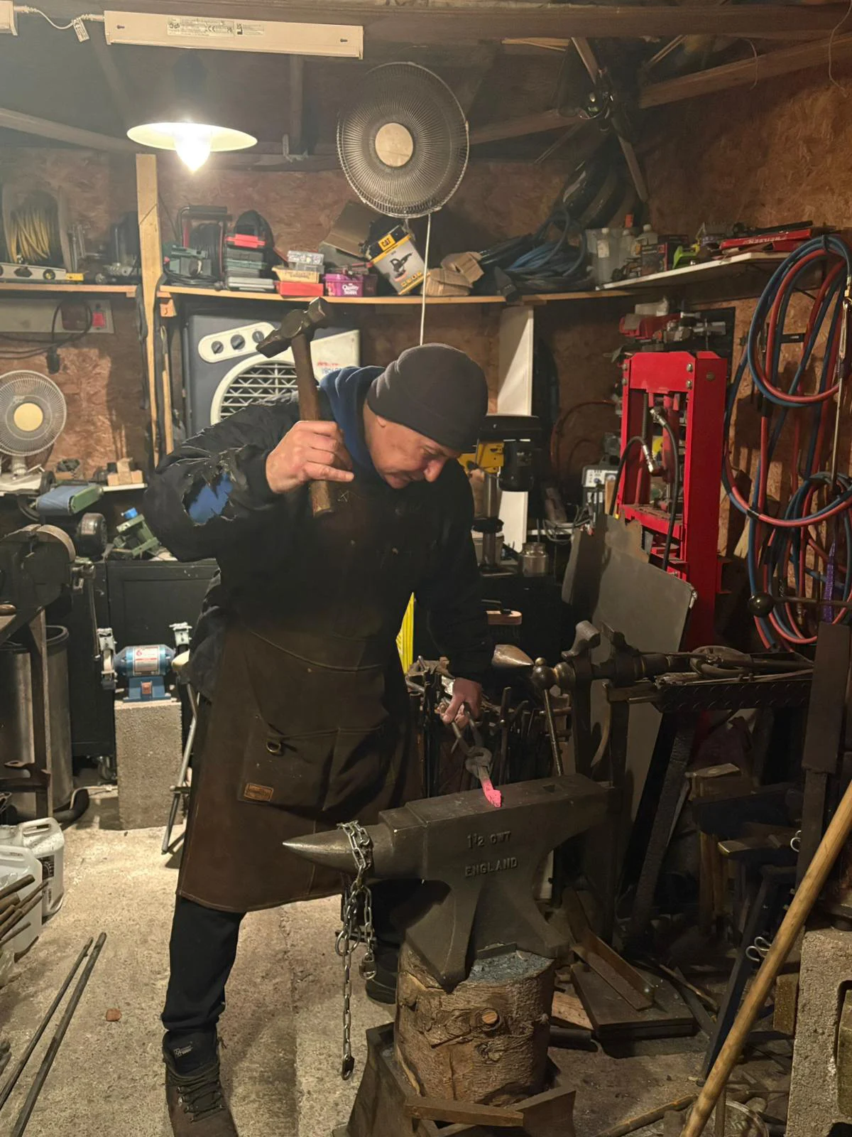 Blacksmith forging metal in workshop