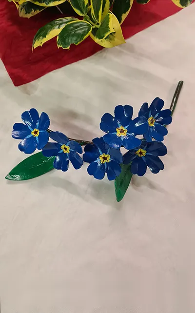 Blue metal flowers artwork on display table.