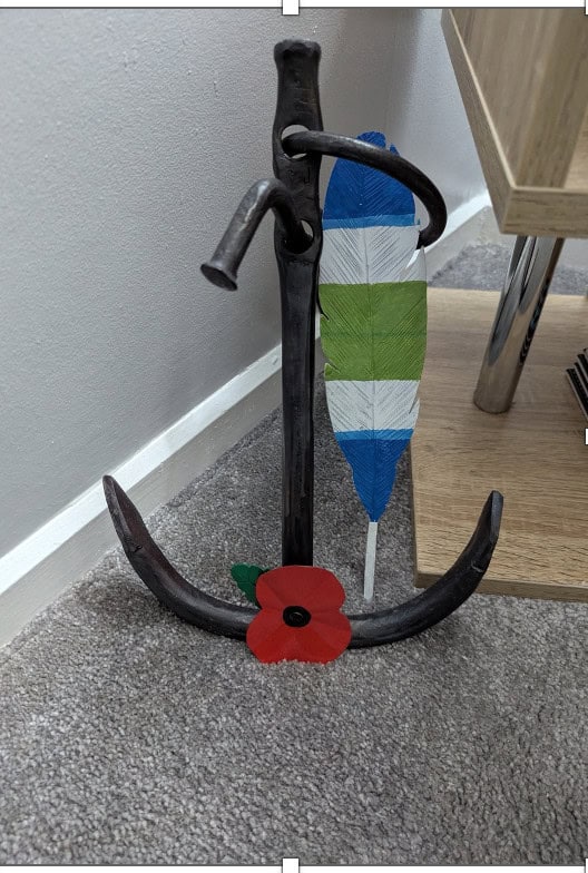Anchor with colorful feather and red flower decoration.