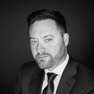 Black and white portrait of a man in a suit for Skyler Construction.