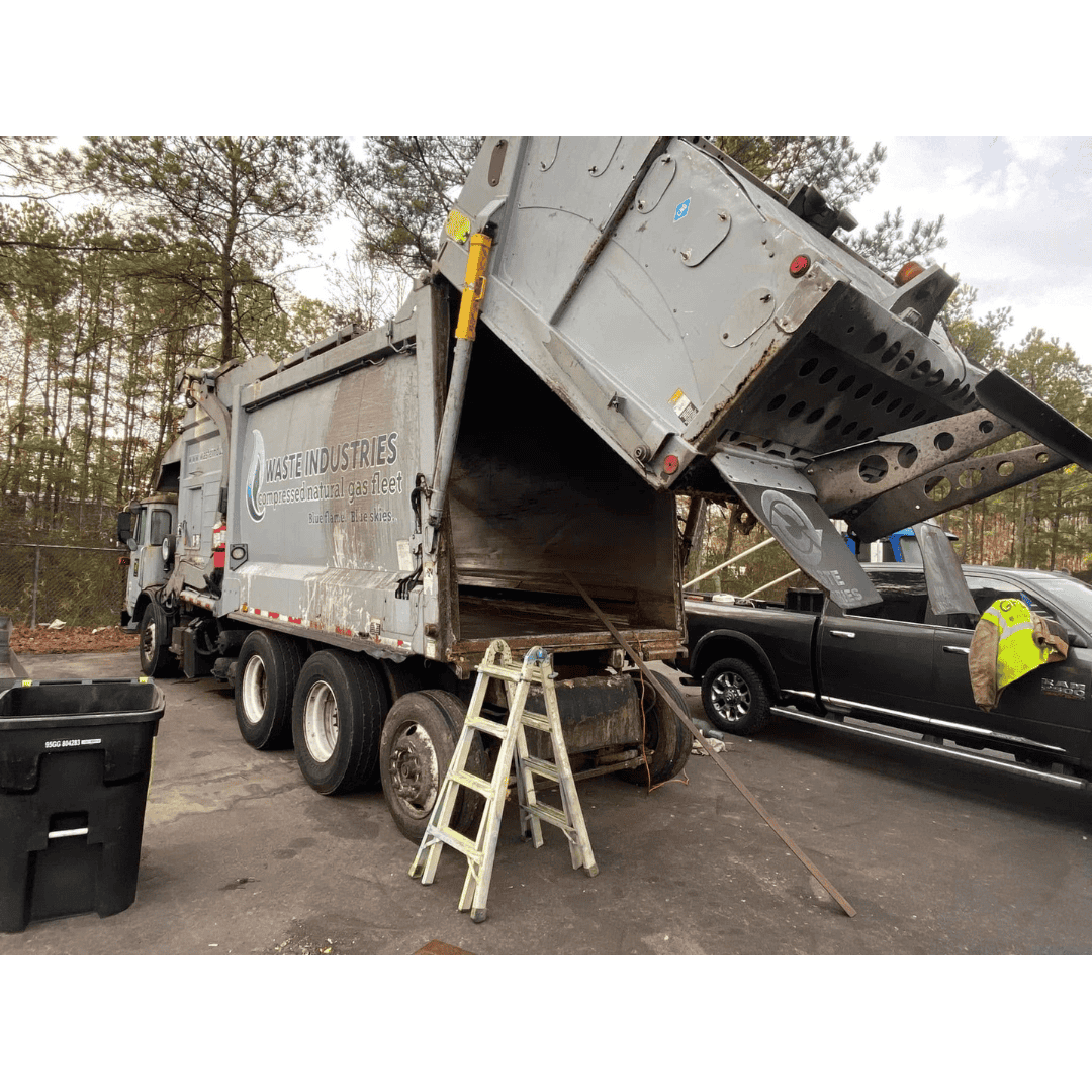 Garbage truck with hydraulic lift for waste collection and disposal.